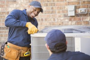 smiling-HVAC-technician-working-on-an-air-conditioner
